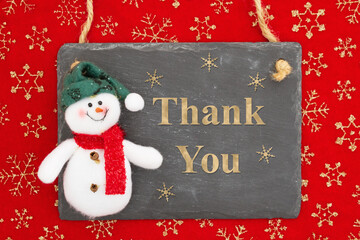 Thank you message on a chalkboard sign with a snowman