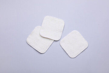 Clean cotton pads on light grey background, flat lay