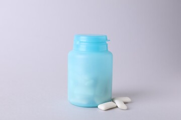 Jar with chewing gums on light grey background