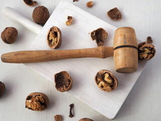 Walnuts, walnut kernels, shells and a wooden mallet