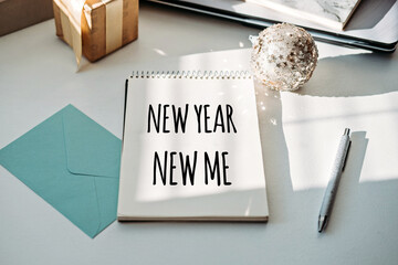 NEW YEAR NEW ME text in open notepad on table at home. Setting goals and new years resolution. New...