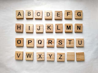 Letters of the alphabet on wooden parts on white background