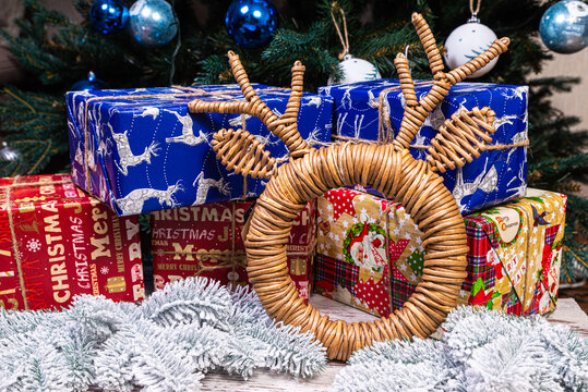 Mock up black poster frame with christmas decoration in home interior, scandinavian style. Green fir branches in a vase, deer and ball on a white table