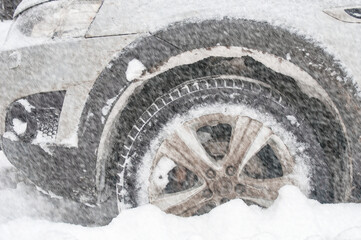 Wheel car stucking in a snowdrift in snowfall. Winter off road