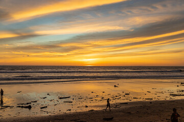 People enjoy the sunset at Seminyak beach near KuDeTa beach club. Bali, Indonesia.