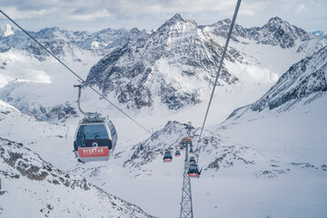Fototapeta na wymiar PITZTAL GLACIER, AUSTRIA - 21.12.22: Gondola cable car and ski slopes in the mountains of Pitztal winter resort, Austrian Alps 