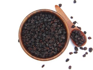 Dried Blackcurrant in a wooden bowl isolated on white background top view 