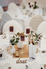 Gedeckter Tisch auf Hochzeitsfeier mit Blumen und Kerzen