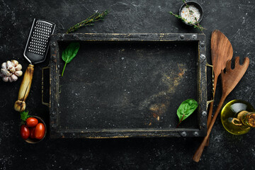 Black stone kitchen background. Spices and vegetables. View from above. Free copy space.