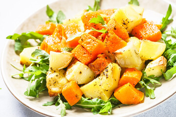 Warm salad with pumpkin, potato and arugula.