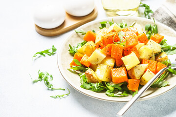 Warm salad with pumpkin, potato and arugula.