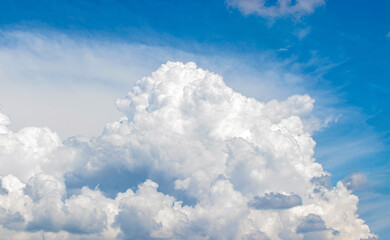 White cumulus clouds in the blue sky, illuminated by the bright spring sun.