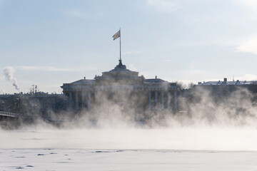 Admiralty house in Saint-Petersburg, Russia. In winter, backlit and through a mist over Neva river