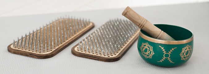Tibetan singing bowl and sadhu board on yoga mat.