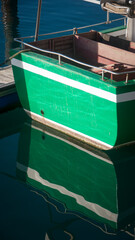Fototapeta na wymiar Barco verde con línea blanca en puerto maritimo