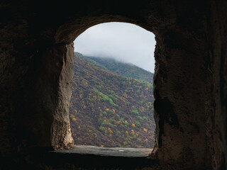 Old stone window. View through arched window in old stone abandoned church. Architecture concept.