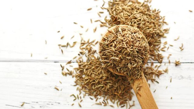 cumin seeds on spoon on table , close up 