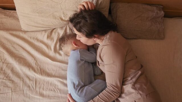 mom next to a sleeping baby. sleeping baby. mom whispers in the ear of a sleeping child. mom kisses sleeping baby