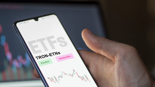 December 2022. An investor analyzes the TRON-ETNs ETF fund on phone screen smallCap midCap equity. German text translated :Kaufen, Verkaufen, TRON-ETNs= buy, Sell, TRON ETNs