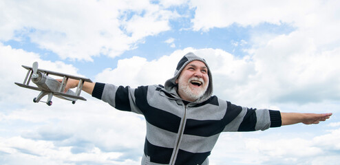 excited senior man on sky background. senior man at retirement. senior retired man with toy plane