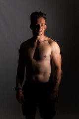 Fototapeta na wymiar Sexy portrait of muscular handsome topless male isolated against a grey background