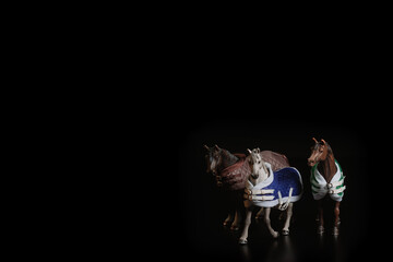 Black toy horse isolated on black background