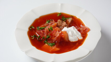 Traditional Ukrainian borscht . White plate of red beet root soup borsch with white cream. Beet Root delicious soup. Traditional Ukraine food cuisine