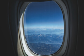 view on rocky mountains from airplane window
