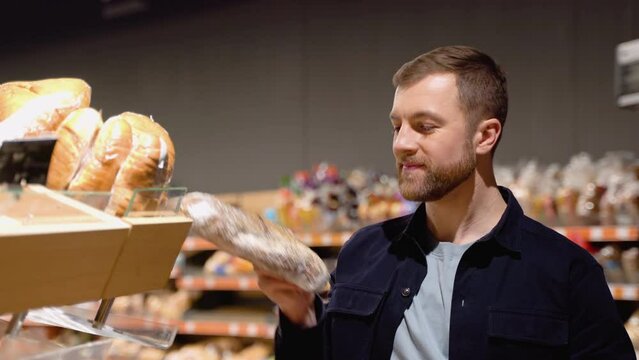 Young man choosing bread at supermarket. Choosing food from shelf in supermarket. Bakery, grocery stores