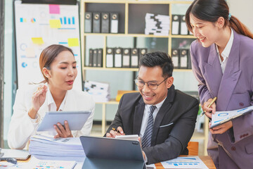 Team of Asian businessmen helping to brainstorm management ideas for the company are expressing joy and happiness that the company has achieved commercial success.