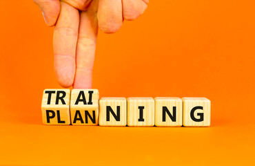 Training and planning symbol. Concept word Training and Planning on wooden cubes. Businessman hand. Beautiful orange table orange background. Business training and planning concept. Copy space.