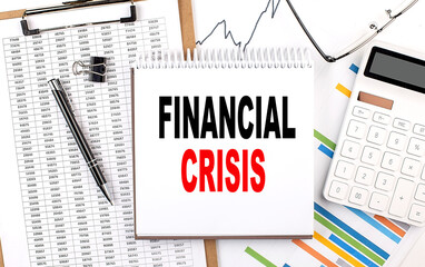 FINANCIAL CRISIS text on notebook with chart, calculator and pen