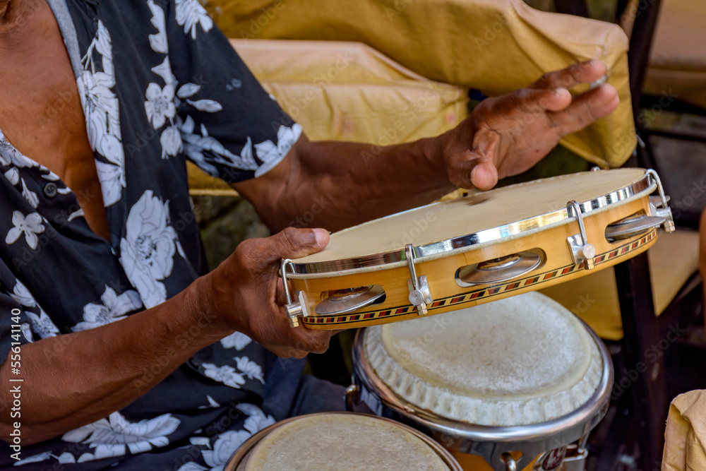 Wall mural detail of musician playing tambourine in the streets of pelourinho in salvador in bahia during a sam