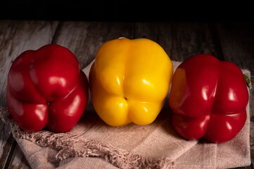 Red and yellow peppers lie on the table in the kitchen 