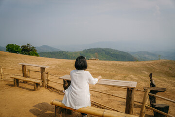 person sitting on a bench and looking mountains view. Traveling concept.