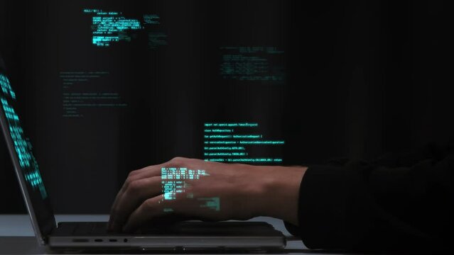 Programmer's fingers quickly type computer code on the laptop keyboard. Neon code holograms. Software development, hacking, coding and cyber technology futuristic concept. High quality 4k footage