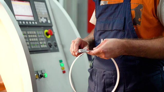Production of seals on the CNC machine. the worker measures the dimensions of the rubber gasket with a vernier caliper