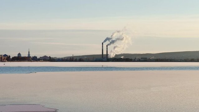 View of the tall chimneys of an industrial enterprise with a chimney polluting the atmosphere. The plant for the production of strategic intercontinental missiles "Topol-M". Russia, Votkinsk 2022