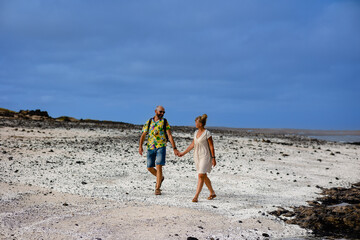 a happy married couple, holding hands, walk along the coast of the famous Fuerteventura beach. Popcorn Beach - coast with popcorn instead of sand, Fuerteventura
