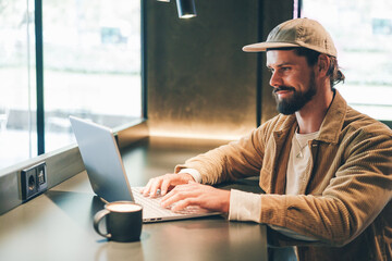 young hipster bearded man using laptop in a cafe