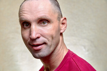 Close-up of his portrait he is a good attractive funny confused adult man in a red T-shirt waiting for news
