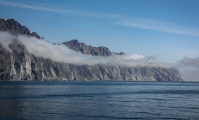 Morning fog over the rocky shore of the Sea of Okhotsk.