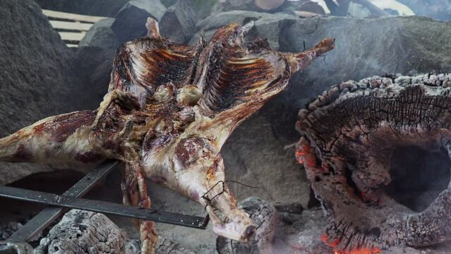rustic lamb barbecue bbq over open fire in Patagonia, Argentina, South America. Asado is a Gaucho traditon with cooking on open flame