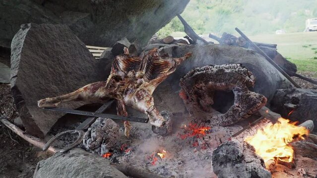 rustic lamb barbecue bbq over open fire in Patagonia, Argentina, South America. Asado is a Gaucho traditon with cooking on open flame
