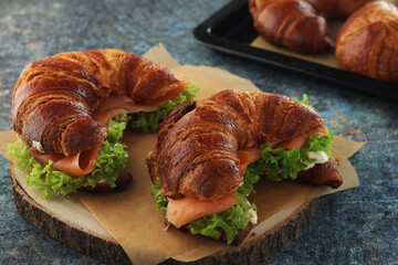 Freshly baked croissants with salmon and salad on the table	