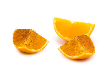 Fresh ripe orange slices covered in ground cinnamon isolated on white background. Copy space.