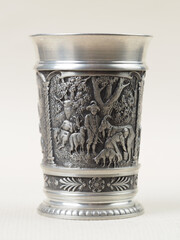 Traditional German vintage pewter wine glass with a bas-relief depicting a shepherd and shepherdess with goats - 556173514
