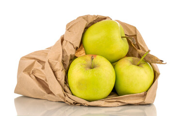 Three green sweet apples with a paper bag, macro, isolated on white background.
