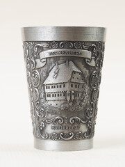 Traditional German vintage pewter wine glass with a bas-relief depicting the Evangelical Deanery building in the city of Herrenberg - 556173708