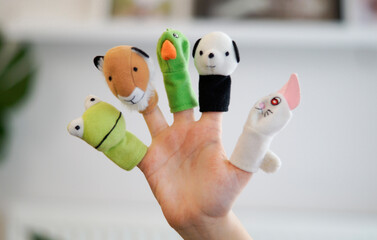 Five animal finger puppets on girl's fingers